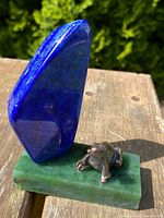 Front view showing bronze turtle figure and vertical lapis lazuli stone on jade base with natural outdoor lighting.