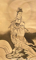 Close up view of Guanyin figure and dragon on the silk scroll, showing detailed brushwork and signature.