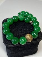 Bracelet coiled on black velvet cushion, showing overall design and condition