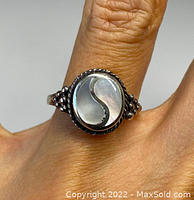Front view of the Yin Yang ring worn on finger, showing detailed mother of pearl inlay and oxidized silver.