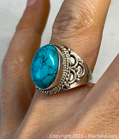 Front and side view of antique Tibetan sterling silver ring with turquoise stone worn on hand.