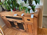 Front view of the oak buffet showing metal accents on the glass door panels and wooden side doors.