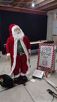 Full view showing the 5' tall automated Santa figure next to the North Pole sandwich sign and small items on floor.