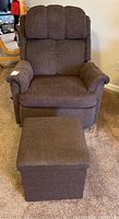 Front view of a brown fabric manual rocker recliner with ottoman in front on carpeted floor