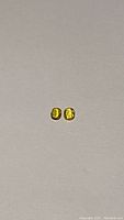 Two small cushion-cut yellow sapphires placed side by side on a white background, showing their color and size.