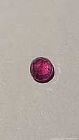 Top view of natural ruby showing hot pink red color and facets