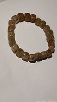 Full bracelet laid flat showing rounded cube-shaped reddish strawberry quartz beads with natural inclusions.