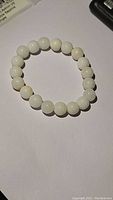 White crystal agate stretchy bracelet laid flat on a light surface.