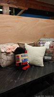 Image showing all bedding items: two comforter sets in packaging, Raptors throw in packaging, and two throw pillows (cream fleece and brown pillow).