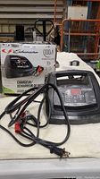 Schumacher battery charger unit with box behind it, showing product name and specifications.