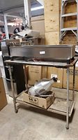 Full view of stainless steel donut maker assembled on metal table