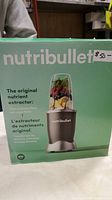 Front of the box showing Nutribullet original nutrient extractor blender with an image of the blender and filled cup, including product claims and multilingual text.