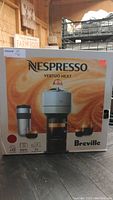 Box of red Breville Nespresso Vertuo Next coffee machine with branding and product image
