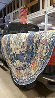 Rug draped over the back of a truck showing full design and size