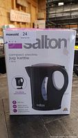 Photo of the Salton electric jug kettle box showing product image and specifications including 1 litre capacity, cordless convenience, BPA free, and stainless steel heating element.