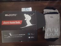 Image showing Wasoto branded black box for electric heated socks and one gray-black heated sock marked XL size.