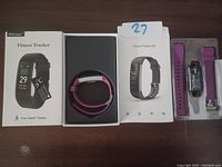 Fitness tracker laid out on table with original packaging, user manuals, and extra bands