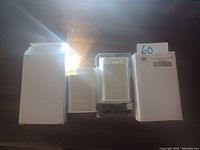 Photo showing hand warmer and light with their original white boxes, positioned on dark surface with part of light being illuminated.