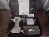 Hard case opened showing folded white HS510 drone, silver battery, manuals, spare props, rings, cable