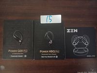 Photo showing three boxed sets of earbuds: Power Q20 Pro, Power HBQ Pro, and ZEN Model ZT02.