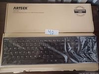 ARTECK HV192 wireless keyboard in original beige packaging, keyboard wrapped in plastic inside box, showing full layout of keys and brand details.