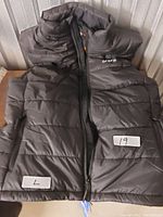 Black Ororo heated vest laid flat showing front side, front zipper, side pockets, and stand-up collar.
