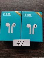 Two boxed i11 5.0 True Wireless Headsets shown in their retail packaging with model and branding visible.