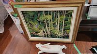 Framed print and ceramic rabbit side by side on wood floor