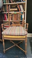 Front view of wood framed armchair showing striped cushion and armrest details.