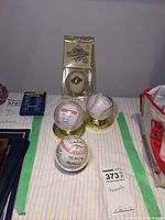 Photo showing all four baseballs in clear protective display cases, including one with World Series logo and three with visible signatures.