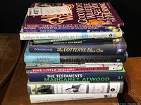 Stack of hardcover books showing titles by Alice Walker, Donoghue, Michelle Good, Margaret Atwood, and Michael Ondaatje