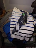 Tommy Hilfiger white sweater with blue and black horizontal stripes, displayed with a packaged tie showing animal design