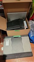 View of packed box containing lapdesk and other office supplies including black leather-like organizer and files.