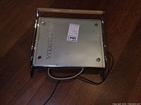 Top view of Vitantonio panini press showing brand name on glass surface and power cord.