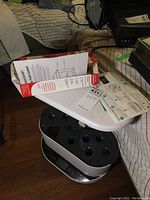 Photo showing the Aerogarden Bounty Trellis system with black lid and seven growing holes visible, along with user manuals and Hydroponic growing system controls.