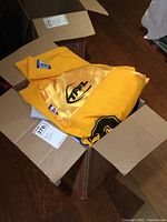 Yellow TFL jersey visible inside a cardboard box