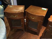Pair of matching vintage wooden cabinets side by side on a wood floor, showing front and top surfaces with some wear and scratches.