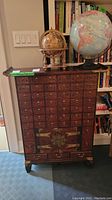 Full-height frontal view of cabinet with globes on top