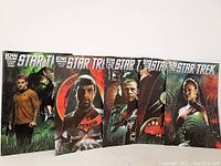 Five Star Trek comic books lined up, showing colorful, detailed covers with characters and sci-fi themes