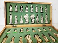Chess pieces arranged inside green felt-lined wooden box lid and bottom