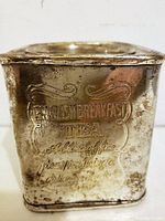 Close-up front view of the metal English Breakfast Tea Tin showing embossed decorative text