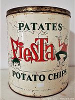 Front side of vintage Fiesta potato chips tin showing brand graphics and character illustrations on a white tin with rust on edges.
