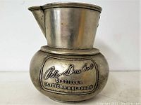 Side view showing embossed Peter Dawson Distiller Dufftown & Glasgow on the bulbous body of metal putter.