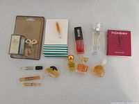 Photo of 12 small perfumes and colognes arranged on a flat surface showing variety of bottles and packaging