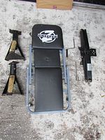 Photo showing Z-Creeper laying flat with two jack stands and a leveler stabilizer arranged around it on a concrete floor.