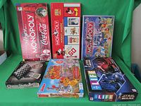 Overview of all six games in the lot arranged on a green backdrop. Shows Monopoly Coca Cola Edition, Monopoly Mickey Mouse 75th Anniversary, Monopoly Disney Edition, Life Star Wars Edition, Lion Guard Surprise Slides Roaring Rescue, and Chess Station computer boxed games.