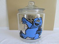 Front side of jar shows Cookie Monster holding a cookies bag in bright blue color.