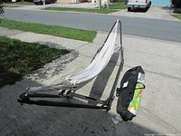 Full view of the portable hammock stand with hammock placed outdoors on a driveway for scale and visual of condition.