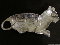 Side angle showing the full length and textured spotted detail of the pewter leopard serving tray with curved tail and defined facial features.