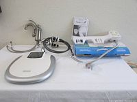 Complete set including FreshSpa Easy Bidet with control dial and hoses, part of scale box visible, and faucets.